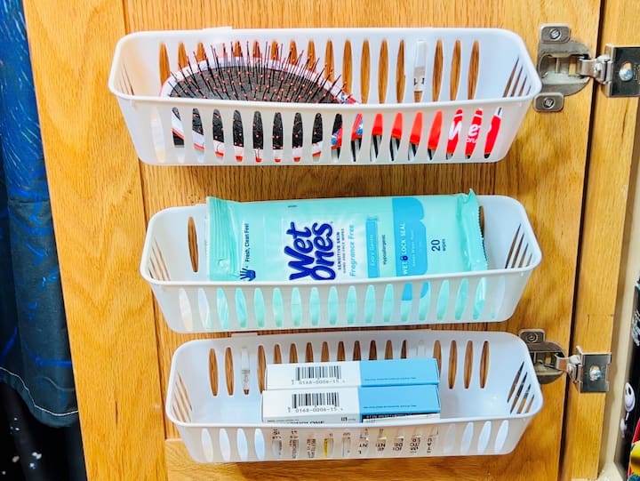 My kid's bathroom has no drawers, we created more space by utilizing the back of the cabinet door for common items. We placed command hooks on the cabinet and then hooked on some dollar store baskets.