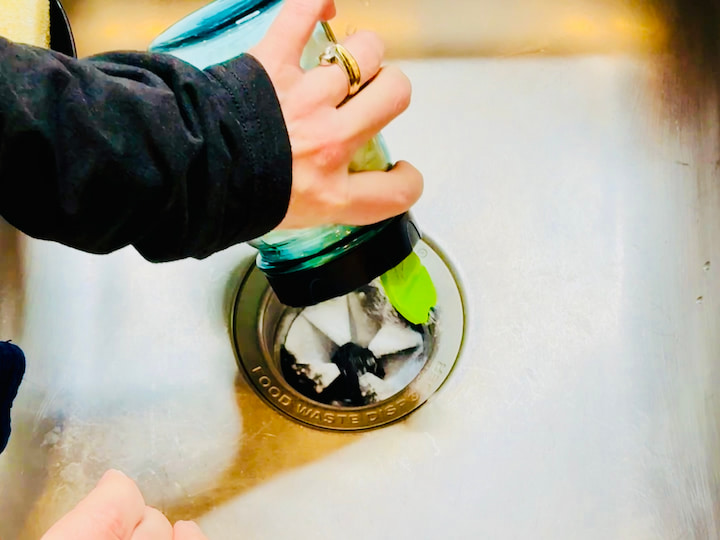 Pouring baking soda in garbage disposal