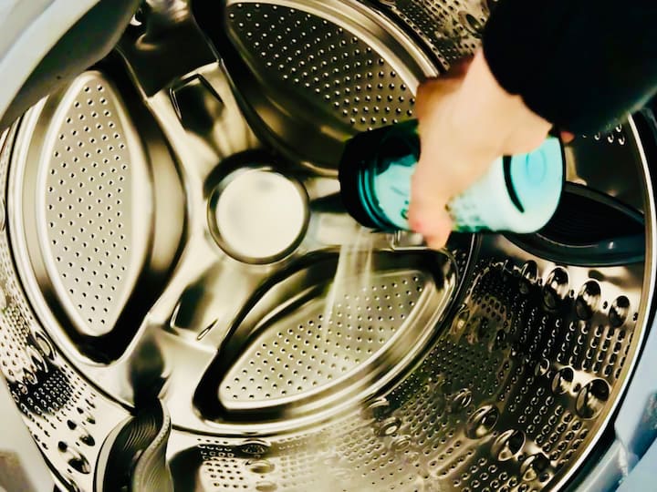 Pouring baking soda in washing machine