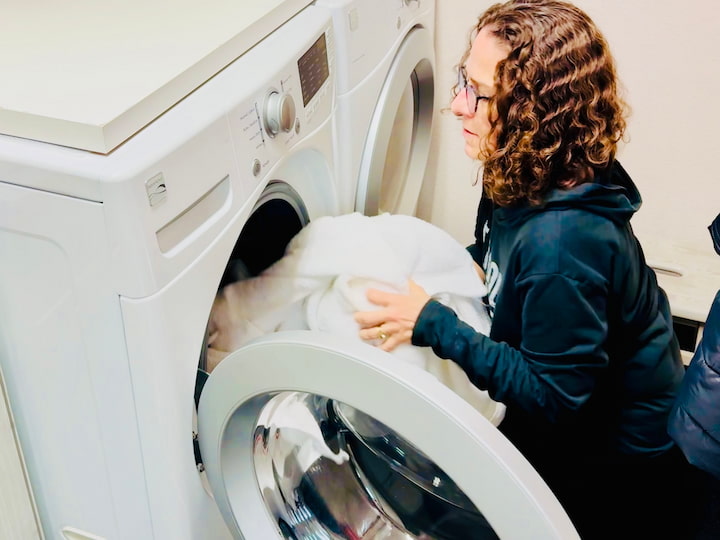 Chas putting towel in washing machine