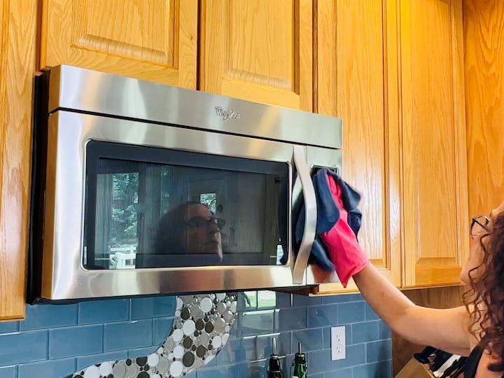 Wipe down refrigerator, handles, and shelves with soapy water. Place a bowl of lemon juice and vinegar in the microwave, heat for 5 minutes, then wipe down interior. Clean oven's exterior, knobs, and keypad. Use self-cleaning mode if applicable.