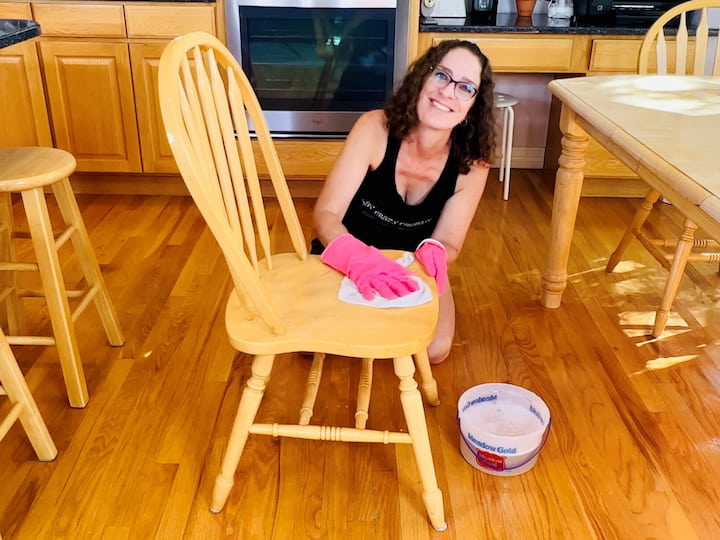 Mix 1/4 cup of Murphy's Oil Soap with a gallon of water.Use a clean washcloth to wipe down wood surfaces, starting with tables and then cabinets.Wipe cabinets from top to bottom, focusing on crevices and areas touched by hands.