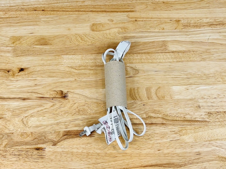 Avoid tangled cords by using a cardboard tube. Cut it in half, insert your cords, and keep them organized without any hassle.