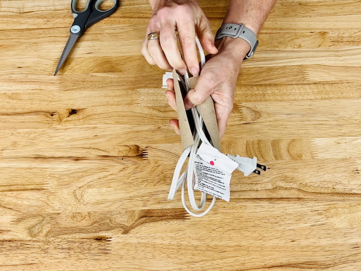 Avoid tangled cords by using a cardboard tube. Cut it in half, insert your cords, and keep them organized without any hassle.