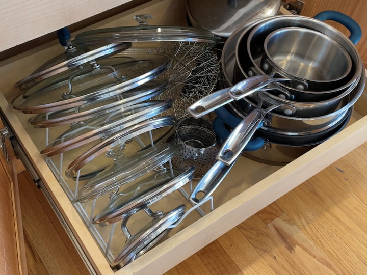 I use one of these Dollar Store racks that are used for multiple things as my lid holders for my pots and pans.