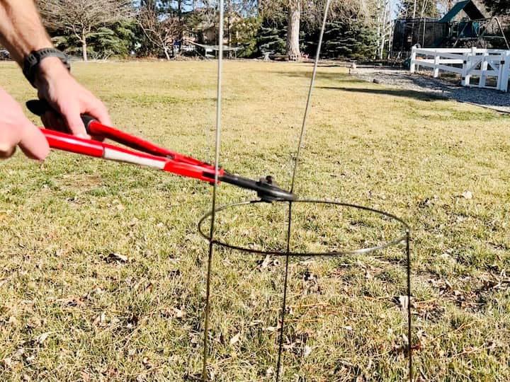 Now that the tomato cage is dry I'm going to flip it over so that the top is the bottom and the legs are standing straight up.  I need to cut these legs off.  I used a bolt cutter because it was handy, but you can use whatever you would like. 