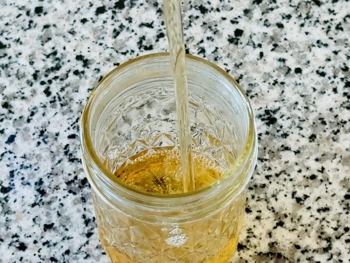 Filling glass jar up with soap