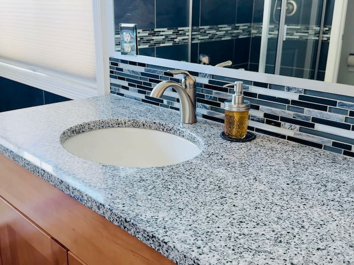 Jar soap dispenser next to sink in bathroom