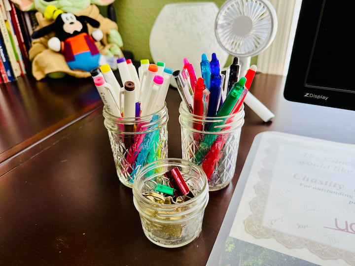 glass jars holding office supplies